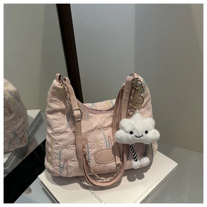 Detailed shot of pink pleated canvas tote bag with embroidery and cloud plush charm