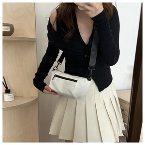 Mirror selfie showing a white nylon crossbody bag with black zipper and wide strap