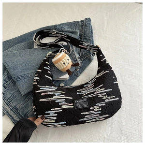 Detail of black nylon dumpling bag with wave embroidery and plush coffee cup charm