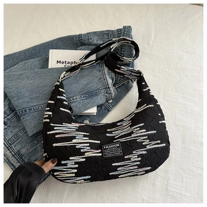 Detail of nylon crescent bag with colorful wavy stripes and fashion instinct label