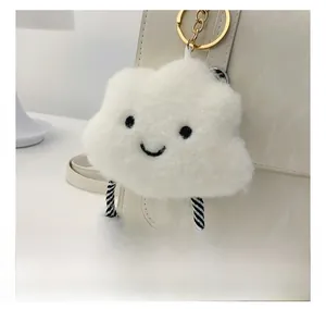 Detailopname van witte pluche wolkenhanger met borduursel aan een leren tas