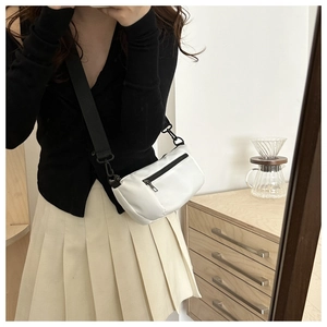 Detail of white nylon baguette bag showing black zipper and adjustable wide shoulder strap