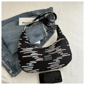 Detail of black crescent nylon bag with colorful wavy embroidery and fashion label