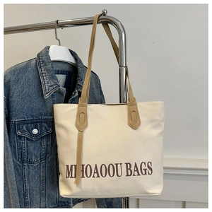 Détail du sac cabas en toile blanc cassé avec anses en cuir marron et imprimé