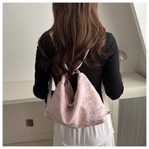 Detailed back view of pink textured nylon crossbody bag with colorful wavy embroidery