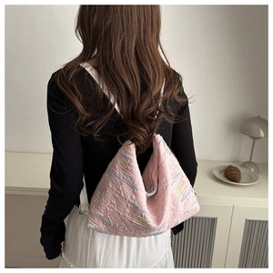 Pink nylon shoulder bag with colorful zigzag embroidery and white strap shown on model
