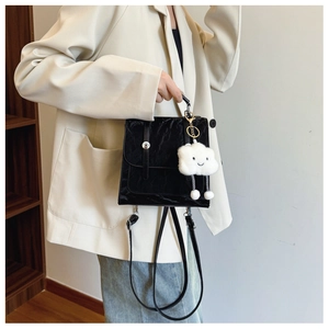 Detail of black pleated crossbody bag with metal lock and cute white cloud charm pendant
