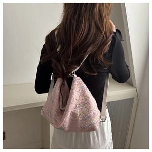Detailed close-up of pink nylon backpack with unique embossed texture and colorful embroidery