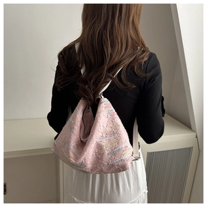 On-body view of pink textured backpack with colorful embroidery and white straps