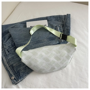 Detail shot of white quilted moon-shaped waist bag with adjustable pastel green strap