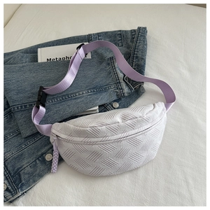 Detail of white woven crossbody bag texture with lavender strap on denim jacket