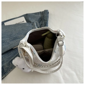 Detail of white canvas tote bag interior with umbrella, wallet, and cloud charm