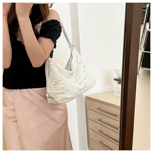 Detailed close-up of white quilted nylon bag with colorful zigzag embroidery stitching