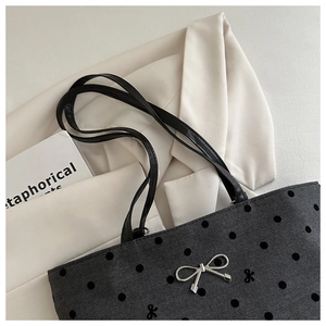 Detail of grey polka dot tote bag featuring silver bow buckle and herringbone texture
