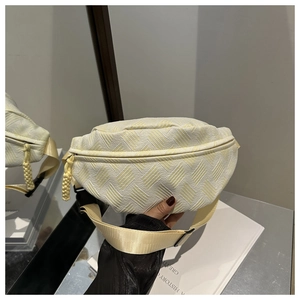 Detail of cream waist bag showing textured woven fabric and rope zipper puller