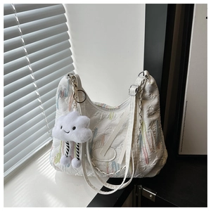 Detail of white tote bag with textured knit fabric and colorful rainbow embroidery