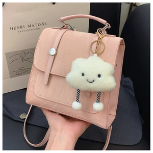 Pink patent leather handbag detail with cute cloud charm and smooth glossy finish