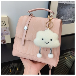 Close-up of light pink glossy handbag featuring wavy texture and cute cloud charm