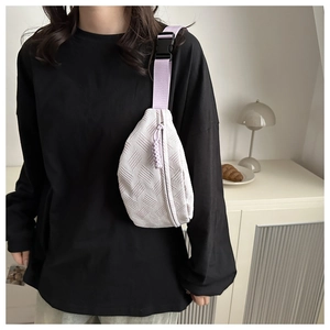Primer plano de bolso bandolera lila con textura tejida y correa ajustable hebilla