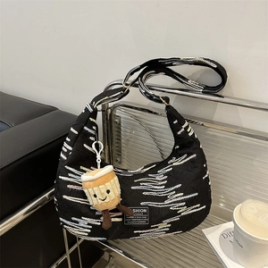 Black nylon crescent bag with wave embroidery and mini coffee cup plush charm