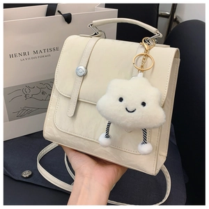 Cream square handbag detail with metallic round buckle and cute cloud plush charm