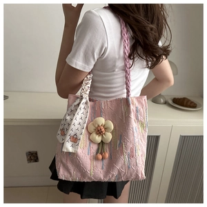 Pink canvas tote bag with textured monogram pattern, woven handle and silk scarf detail