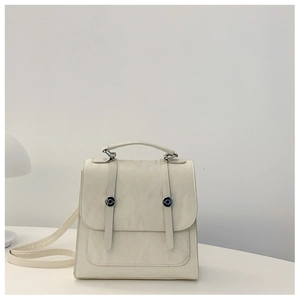 Detailed macro view of cream PU leather texture and silver buckle accents on the backpack