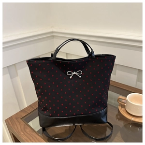Detailed view of polka dot backpack with silver metal bow and sturdy faux leather base
