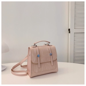 Close-up of pink glossy patent leather texture and silver buckle on a stylish backpack