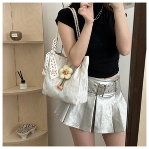 Detail of white jacquard tote bag with sunflower charm and printed silk scarf accessory