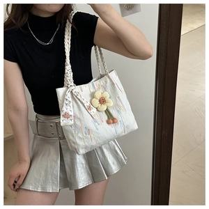 White woven tote bag with 3D yellow flower pendant and silk scarf on the handle