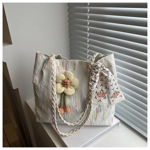 Detail of white jacquard tote bag with FF texture, floral pendant and woven handle