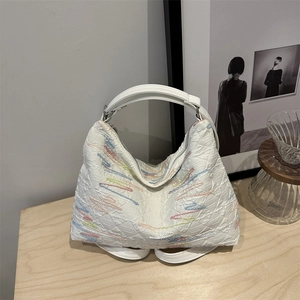 Quilted white nylon handbag featuring colorful wave embroidery and crescent moon shape