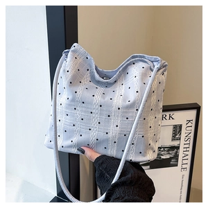 Détail du sac seau bleu clair à pois noirs et rayures de dentelle blanche
