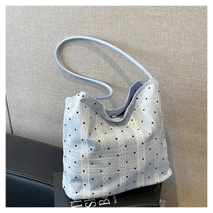 Détail du sac seau bleu clair avec pois blancs et rayures en dentelle sur textile