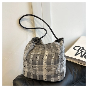 Détail du sac seau minimaliste noir et blanc avec texture quadrillée et pois
