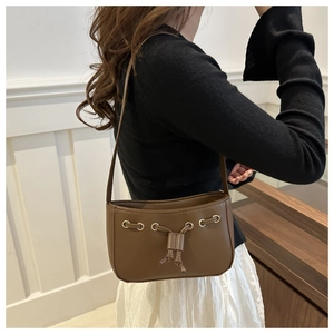 Detail of vintage brown shoulder bag with metallic eyelets and decorative drawstring