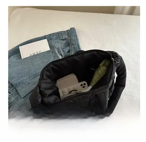 Macro view showing large capacity of black quilted tote bag with daily essentials
