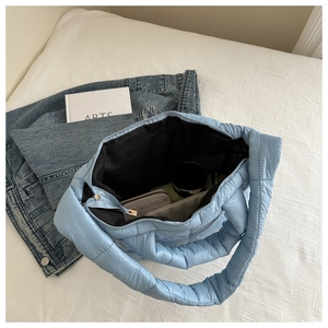 Interior view of large light blue quilted tote bag showing spacious storage capacity
