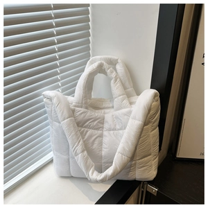 Detailed view of white quilted tote bag featuring a soft padded puffer nylon texture