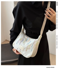 Detail of white nylon dumpling bag featuring colorful embroidery and logo patch