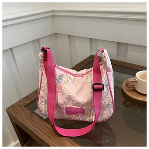 Detail of pink nylon shoulder bag with 3D embossed texture and colorful fringe accents