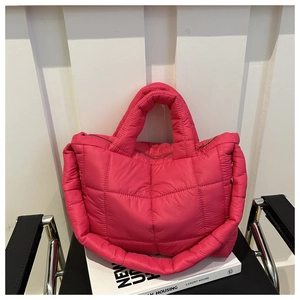 Macro shot of rose red quilted puffer tote bag with premium down-filled nylon texture