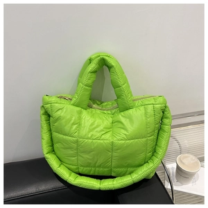 Detail view of fluorescent green quilted tote bag with padded texture and top handles