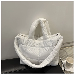 Macro detail of white quilted puffer tote bag with glossy finish and metal zipper