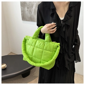 Detail of neon green quilted puffer tote bag made of lightweight nylon with soft handle