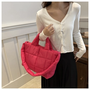 Bright pink quilted puffer tote bag shown on model for size and style perspective