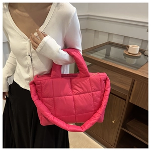 Detail of hot pink quilted tote bag showing puffer texture and padded handles