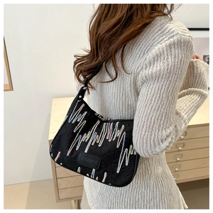 Detail of black nylon shoulder bag with colorful wavy embroidery and brand leather patch