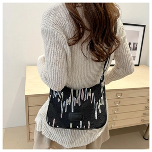 Close-up of black nylon crossbody bag featuring colorful wavy stitching and brand logo